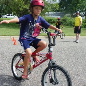 Learning to use turn signals at a Wise Bike Wednesdays rodeo training course lead by instructors of BikeMN, so biking to school is fun.