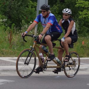 A colorful fall photo this couple, on a tandem bike. are retracing some of the Minnesota Ironman Bike Ride routes on a beautiful fall weekend.
