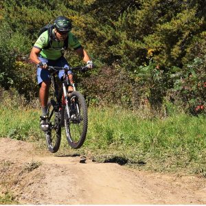 This cyclist keeps a steady eye ahead as he encounters an undulating stretch in the mountain bike trail.