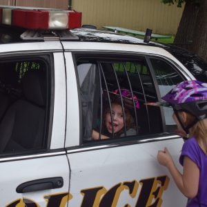 With helmets sized Passport participants move to the last station. A citation for a DQ ice cream by a police officer. This young cyclist wanted to check out the back seat of a squad car.