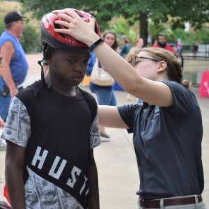 Another lucky cyclist at the Safety Safari having his helmet sized by the Minnesota Brain Institute.