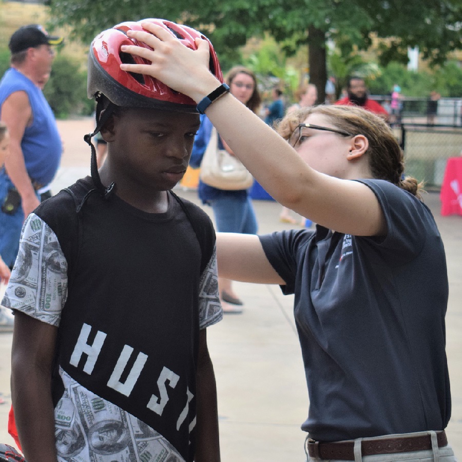 Another lucky cyclist at the Safety Safari having his helmet sized by the Minnesota Brain Institute.