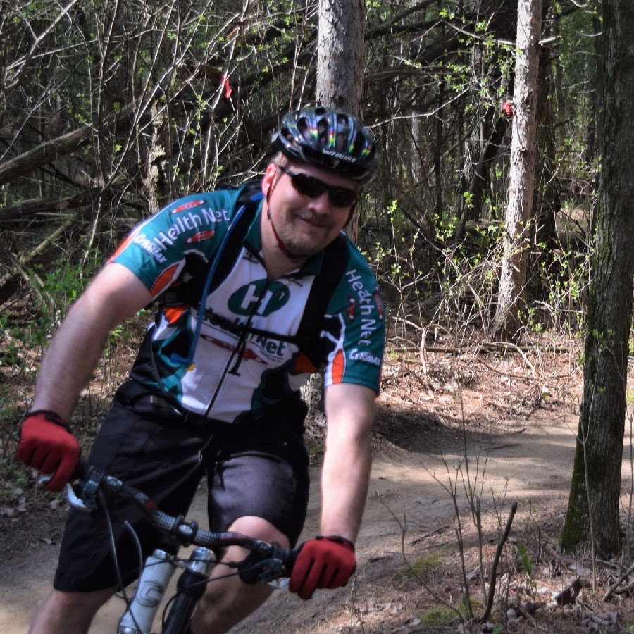 Another happy mountain biker riding through the forests of Lebanon Hills Park.
