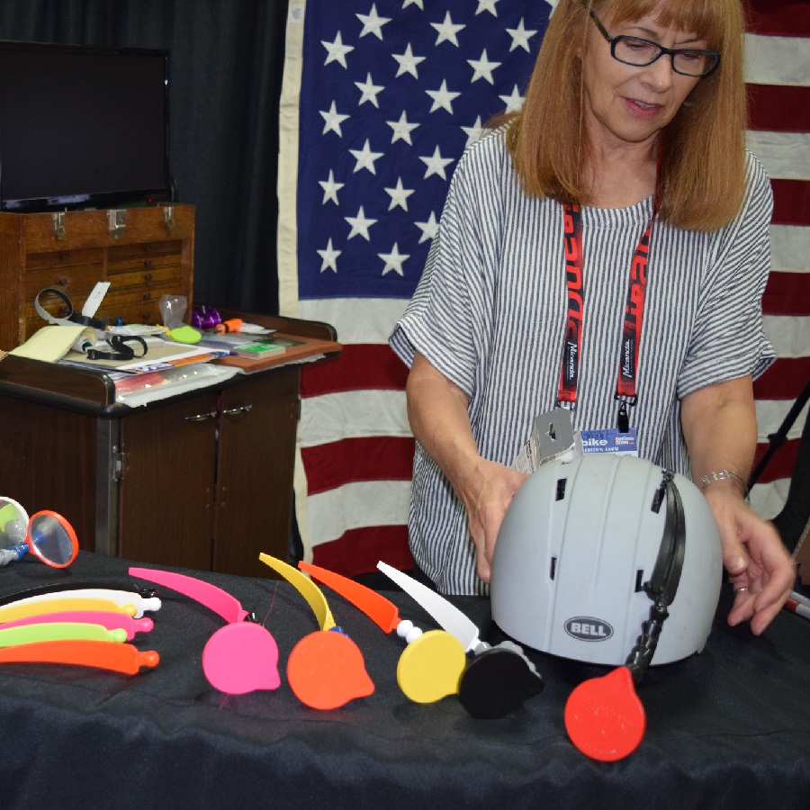 Here a manufacture is showing and demonstrating a colorful line of helmet mirrors at Interbike