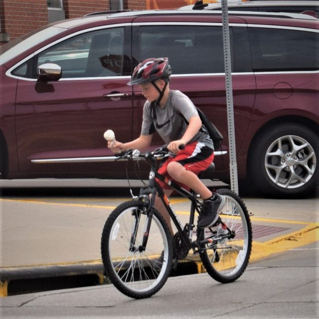 Here on last year's RAGBRAI we caught this young cyclist carrying his ice cream cone, with anticipation, trying to make it back to his camp site before it melted.