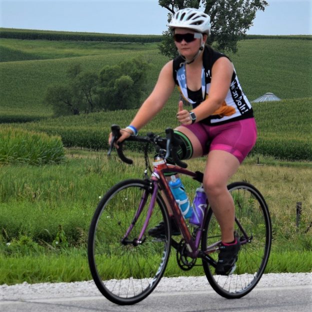 n this bike pic, we caught this biker chick pedaling her bicycle down the road into the Thursday morning sun. This picture was captured a couple weeks ago on RAGBRAI 2018.